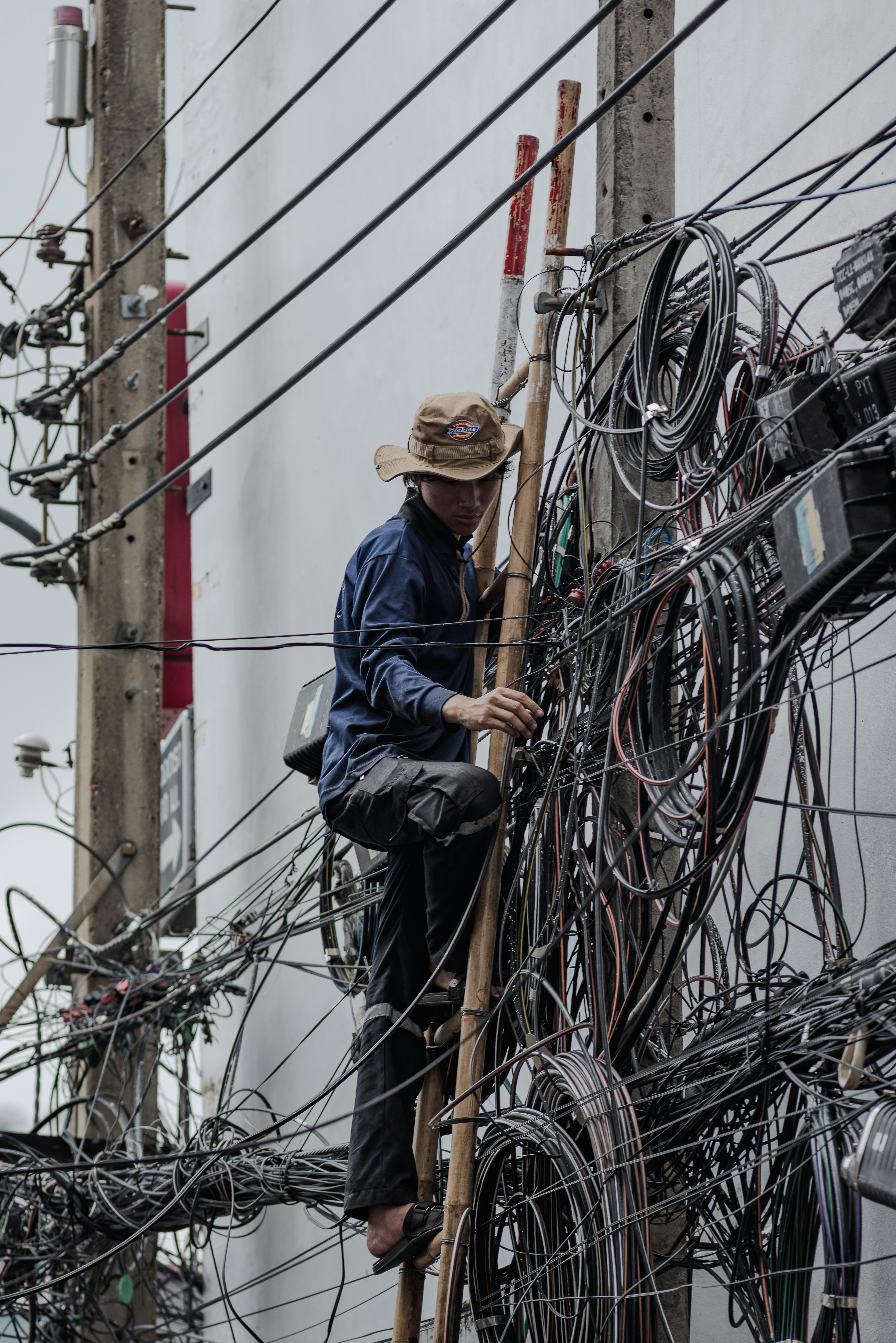 Man Up Utility Pole Surrounded By Messy Wiring