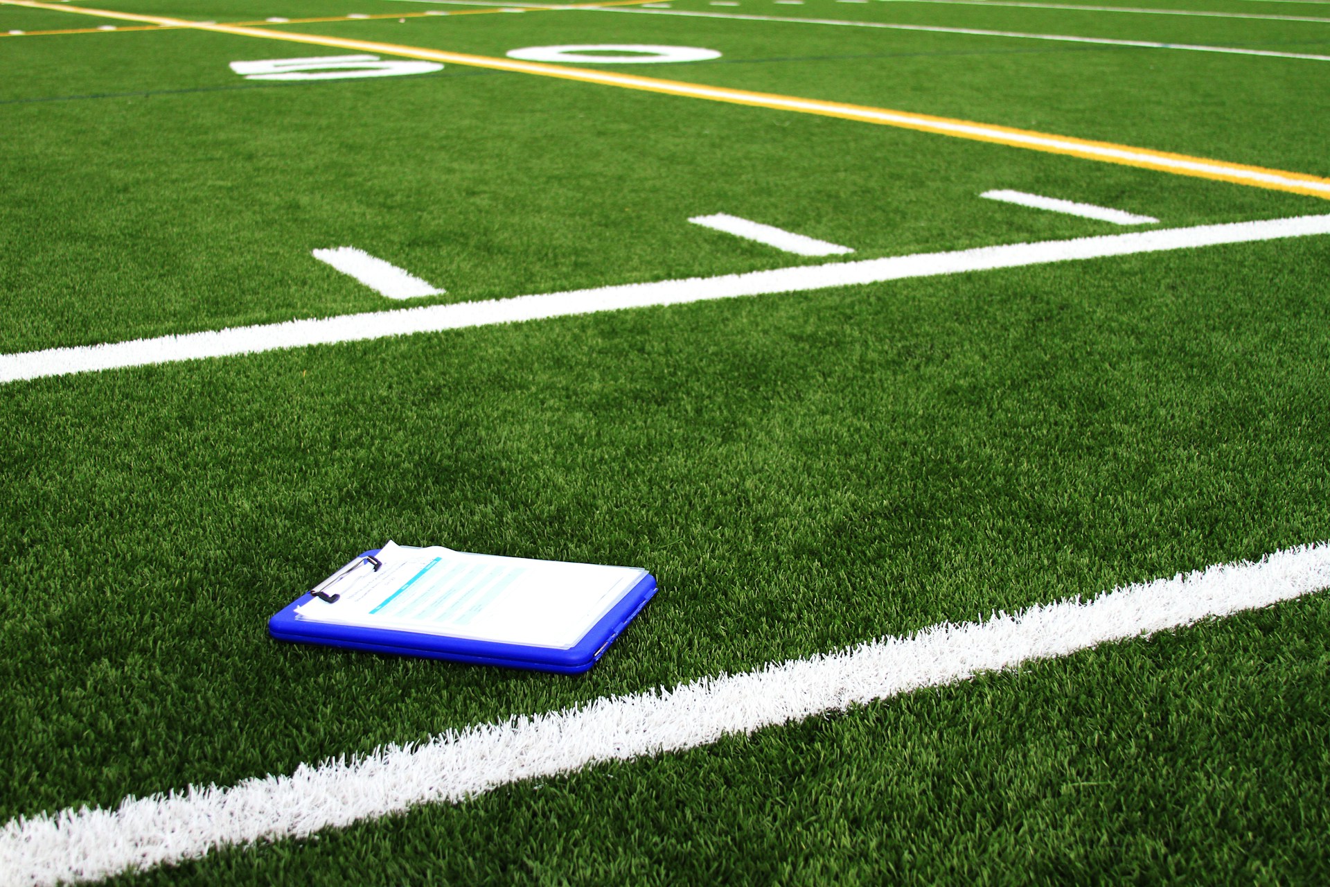 A notebook sitting on the side of an American Football pitch